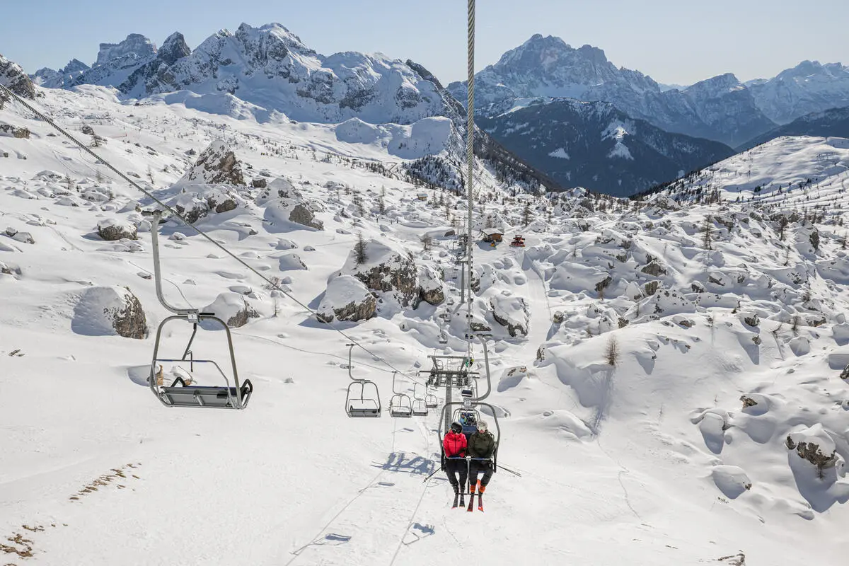 two-man chairlift travels over a snow-covered rock garden