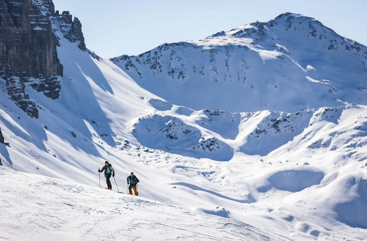 two ski tourers on the upwards journey through snowy mountainscape